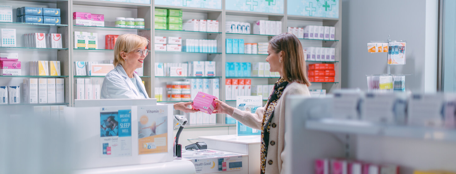 Apothekerin lächelt Medikament an